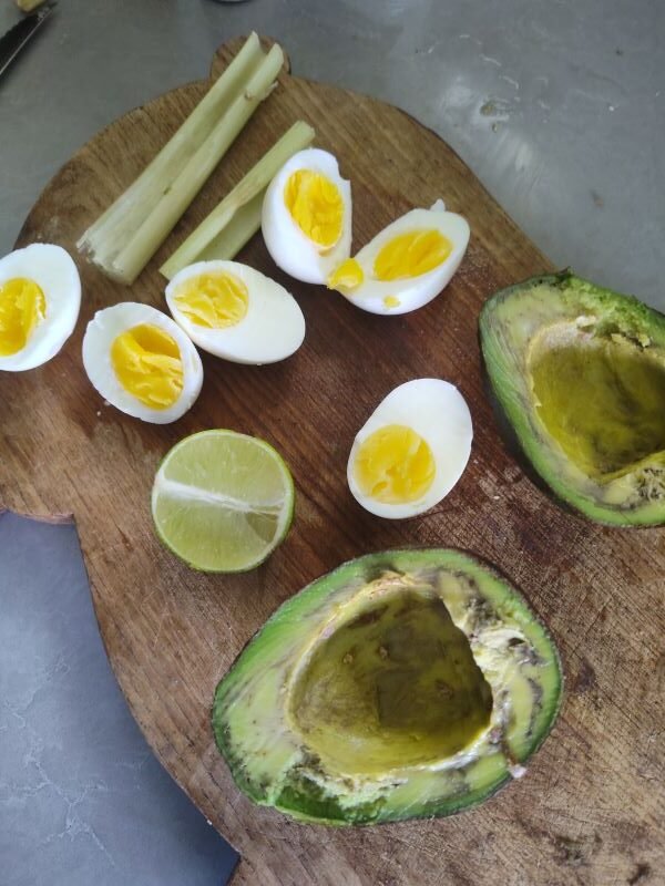 In the bowl with the egg yolks add the avocado, lime juice, cilantro, minced garlic, onion powder, sour cream and salt to taste and mix together